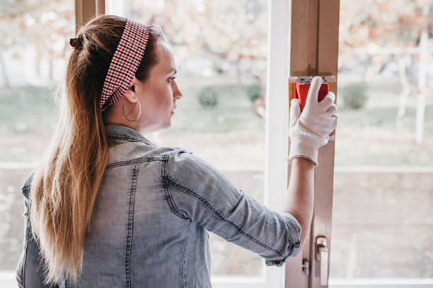 istock Charming young woman fixing windows in the apartment 963801542