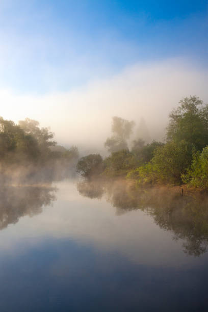 Photo of summer rural  landscape with river and fog