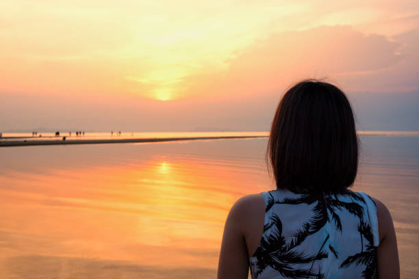 istock Woman watching Sunset at the beach 963804666