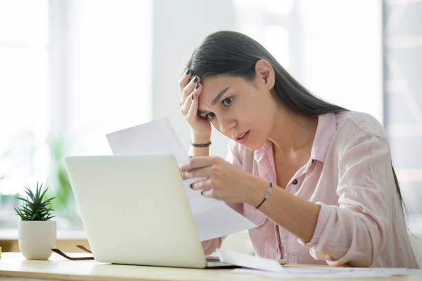 worried frustrated woman shocked by bad news while reading letter - unemployment fear depression women imagens e fotografias de stock