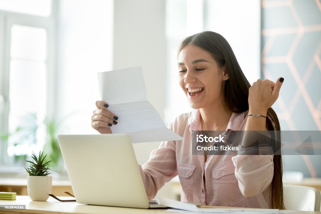 Heureuse jeune femme excitée par la lecture des bonnes nouvelles dans la lettre - Photo de Université libre de droits