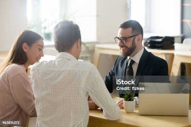 Friendly Lawyer Or Financial Advisor In Suit Consulting Young Couple Stock Photo - Download Image Now