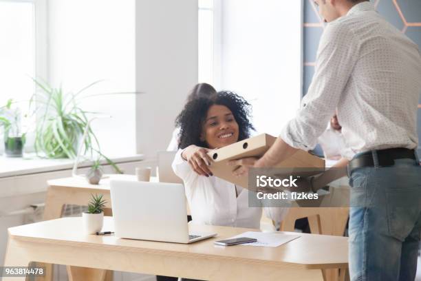 Smiling African Employee Taking Pizza From Courier Office Food Delivery Stock Photo - Download Image Now