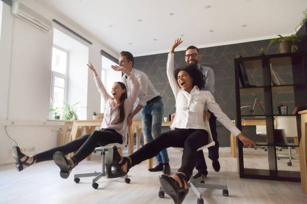 istock Millennial multiracial people having funny ride on chairs in office 963814522