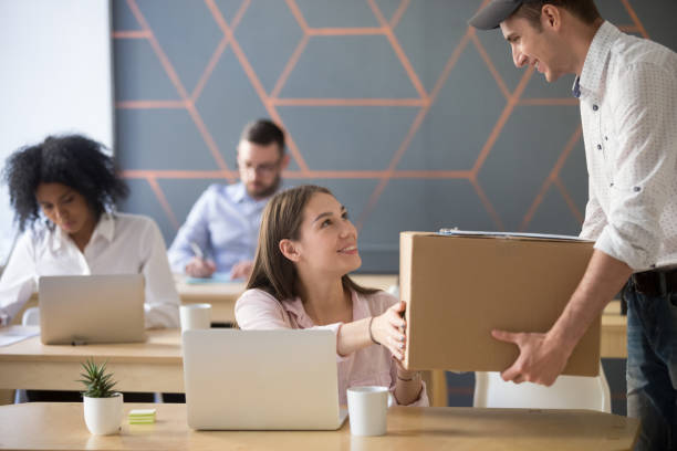 Delivery service concept, woman receiving parcel from courier in office