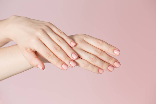 istock Woman's fingers with pink manicure 963815114