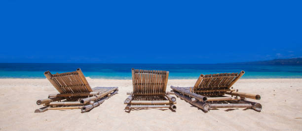 istock Relaxing couch chairs on white sandy beach at Philippines 963817666