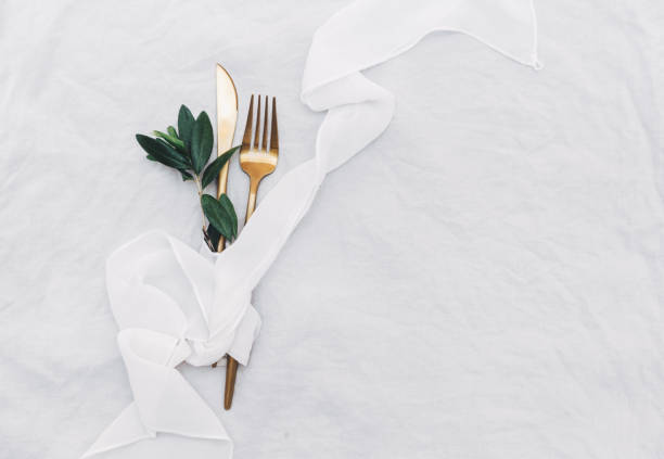 Flat lay gold cutlery with olive branch. Top view, copy space