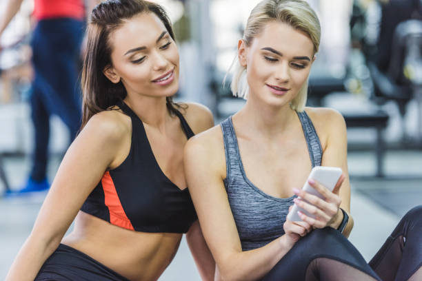 istock young sportive women  using smartphone at gym 963834616