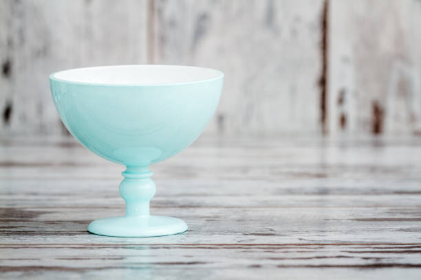 Turquoise plastic ice cream bowls on white wooden background