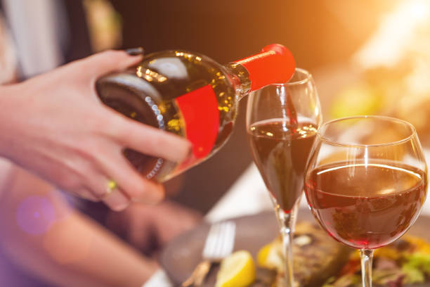 istock Waiter pouring wine into the glass in restaurant 963839296