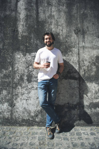 istock Happy guy standing in the sun with drink 963845580