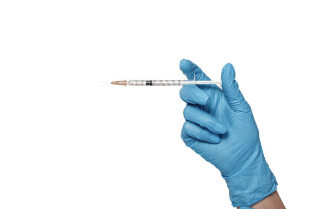 la main dans le gant bleu tenant la seringue - cold and flu vaccination injecting aids photos et images de collection