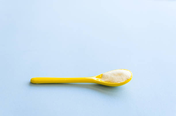 istock Spoon with sugar close-up on a light blue background 963851472