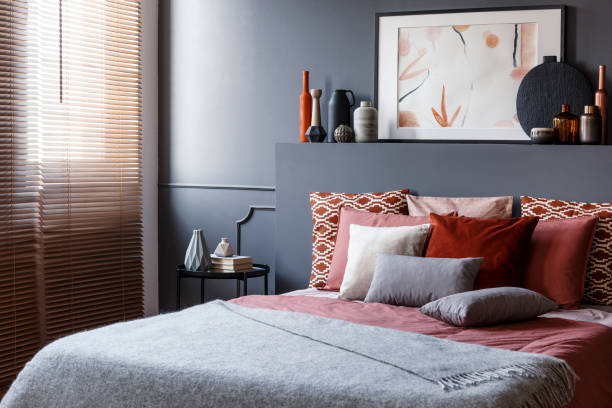 istock Pillows on a double bed next to a bedside table, decorations and painting above in a bedroom interior 963854262
