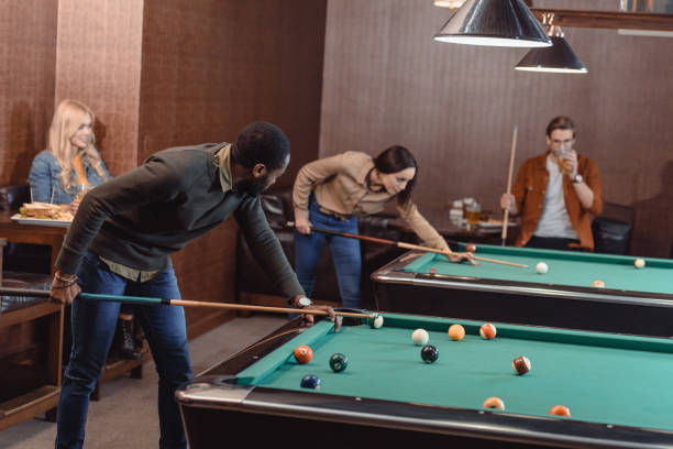 istock young successful multiculture friends playing in pool at bar 963854872