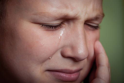 close up portrait of a young boy crying