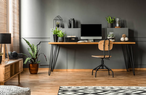 foto reale di un interno scuro con scrivania, sedia e computer in legno nello spazio studio nel mezzo - desk office home interior house foto e immagini stock