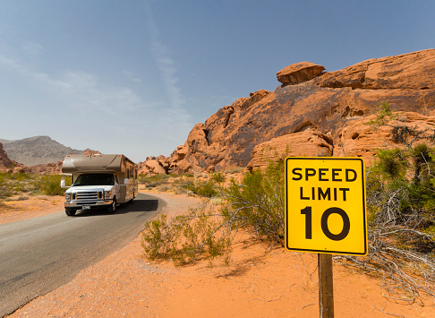 An RV motor home is driving past a speed limit sign in the desert of the  alley of Fire State Park (Nevada, USA)