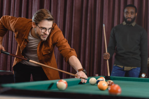 istock handsome man playing in pool at bar with friend 963862660