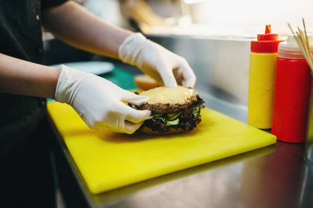 istock Male cook prepares fast food, burger preparation 963868280