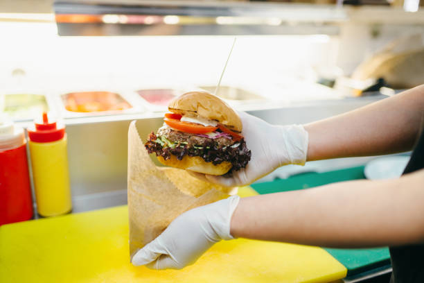 istock Chef puts burger in to the cardboard package 963868390