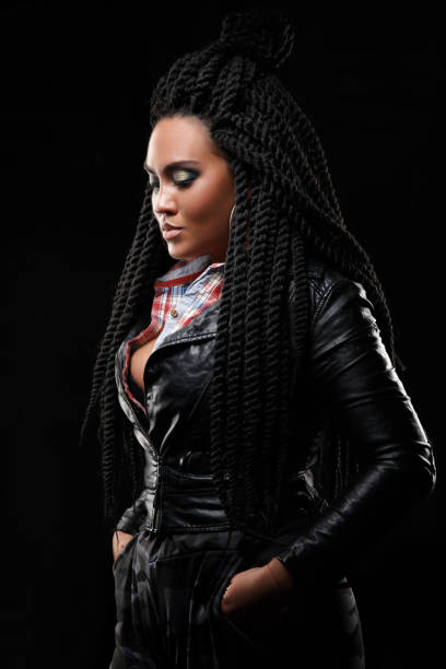 istock Girl in a leather jacket. Black background. Creative hairstyle, dreadlocks 963893106