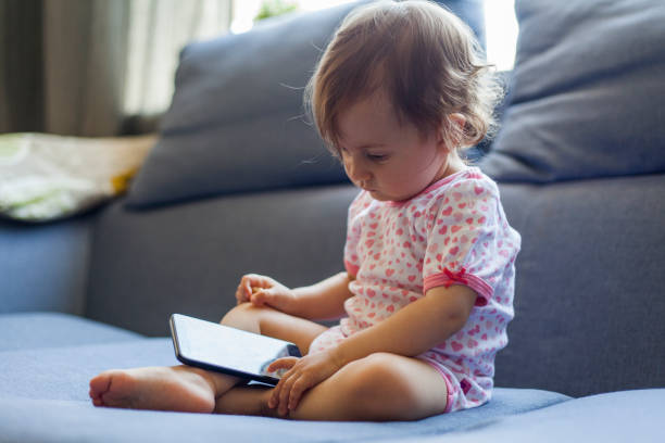 istock baby girl watching a mobile phone 963893722