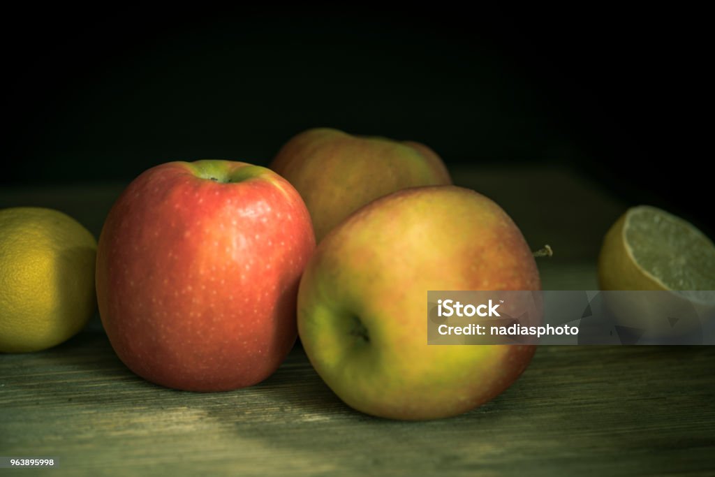 Apples in a country house kitchen Apples and lemons on a rustic wooden country house table. Agriculture Stock Photo