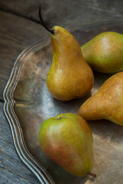 istock Pears on a tray and an old wooden background. 963905386
