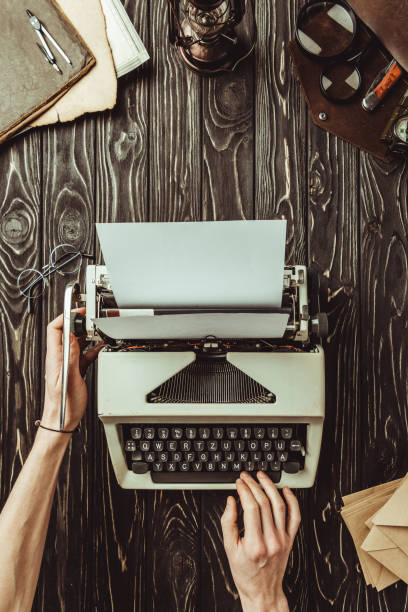 istock partial view of writer hands, typing machine and envelopes on wooden tabletop 963907728