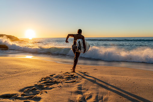 Surfer en el agua llevando su tabla photo