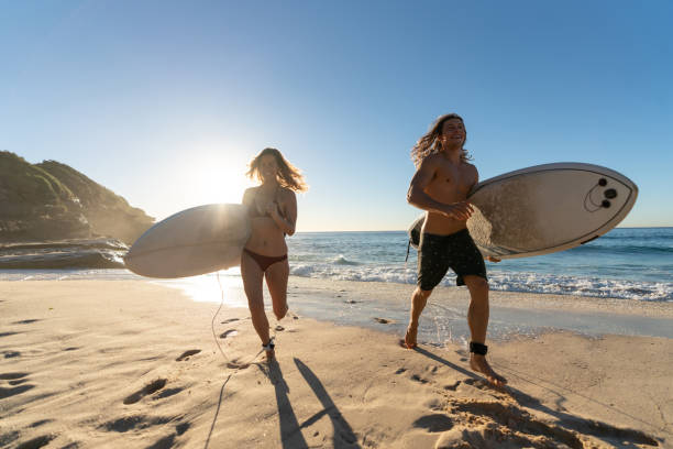 istock Happy couple having fun surfing at the beach 963908694