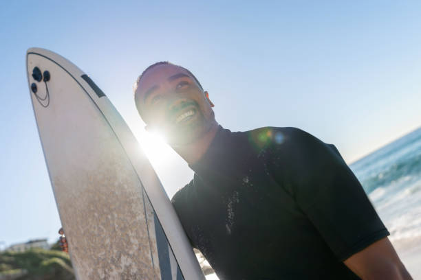 istock Male surfer at the beach looking very happy 963908700