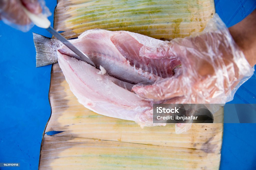 Men selling and preparing grilled fish 30-39 Years Stock Photo