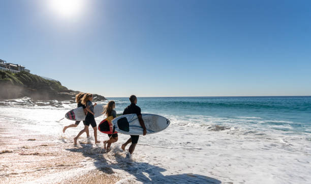 Happy group of friends surfing at the beach Portrait of a happy group of friends having fun surfing at the beach - summer lifestyle concepts sports training australia stock pictures, royalty-free photos & images
