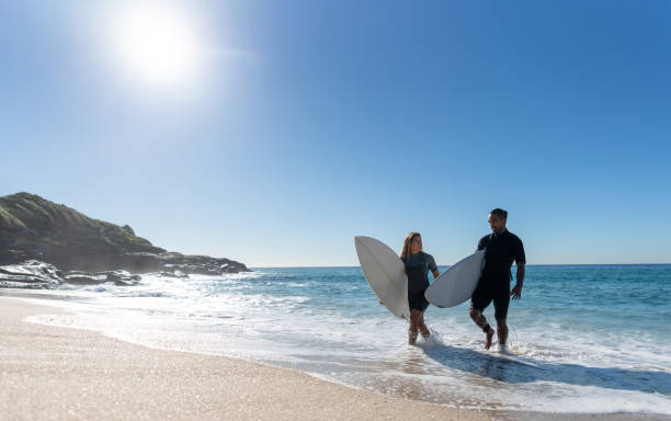 istock Happy couple having fun surfing at the beach 963911486