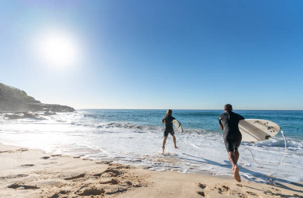 istock Happy men having fun surfing at the beach 963911532