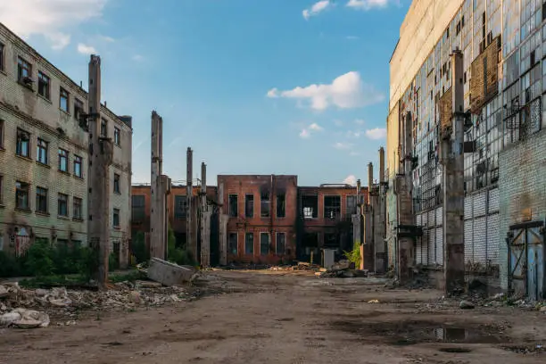 Photo of Territory of abandoned industrial area waiting for demolition. Broken and burnt buildings. Former Voronezh excavator factory