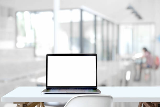 istock Mockup blank screen laptop on wood table in co-working space. 963948236