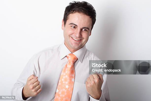 Joven Sonriente Hombre De Negocios Mostrando Fists Foto de stock y más banco de imágenes de Actividad móvil general - Actividad móvil general, Adulto, Alerta