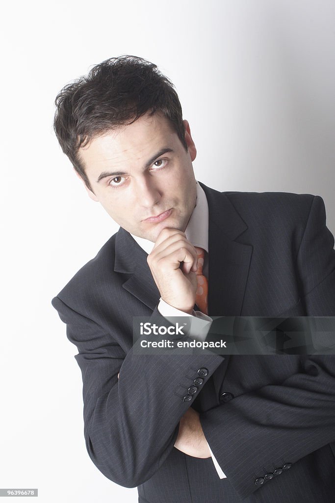Pensare Uomo d'affari in tuta con la mano sul mento - Foto stock royalty-free di Adulto