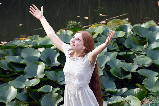 jeune femme heureux se lève les mains au ciel - human hand earth praying moving up photos et images de collection