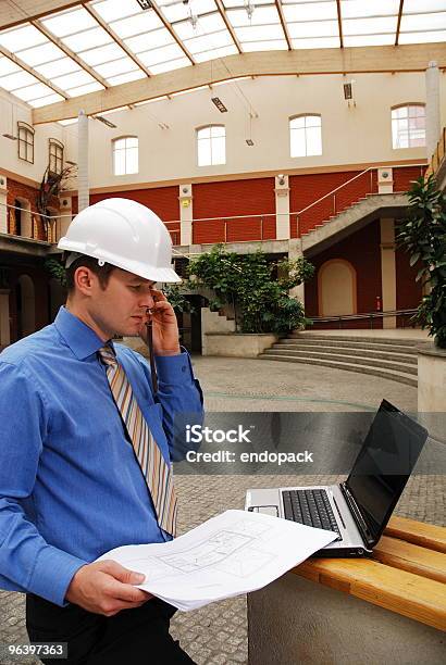 Contratista En Casco Llamar Por Teléfono Y De Trabajo Con Computadora Portátil Foto de stock y más banco de imágenes de Acera