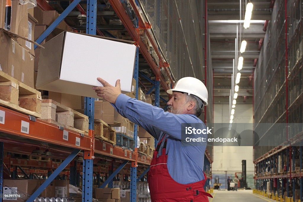 worker  putting box on  shelf in warehouse  Picking Up Stock Photo