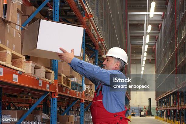 Worker Putting Box On Shelf In Warehouse Stock Photo - Download Image Now - Picking Up, Box - Container, Heavy