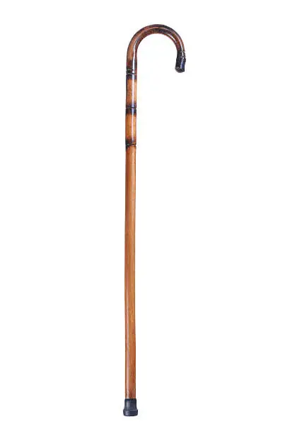 Photo of Simple brown and black wooden cane on a white background 