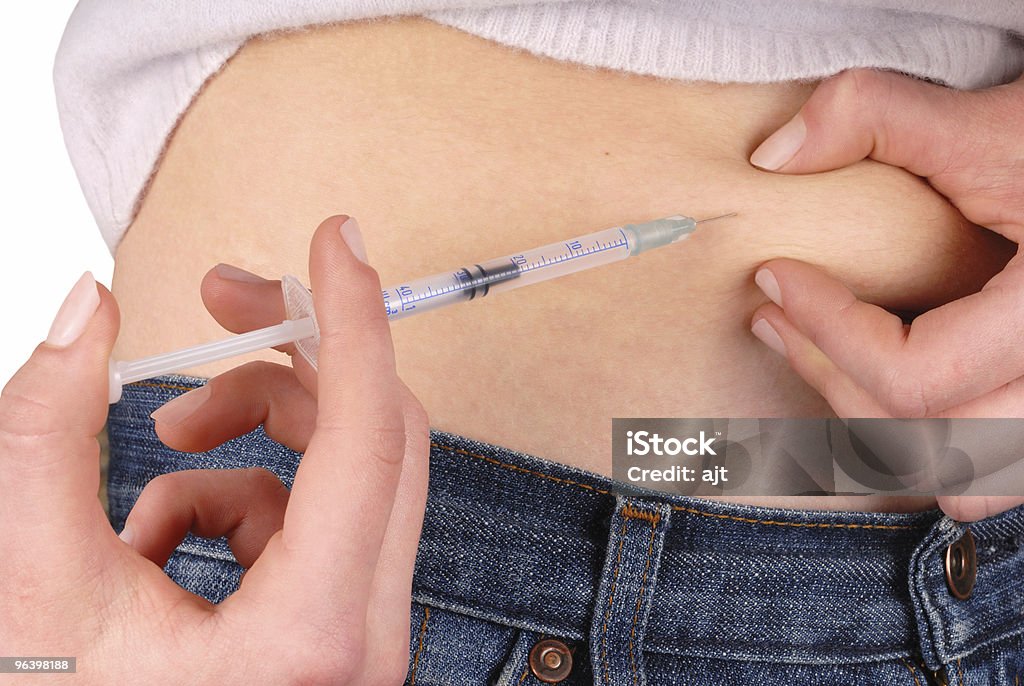Woman receiving an insulin injection to her stomach Teenage girl with syringe in hand injecting insulin Adult Stock Photo