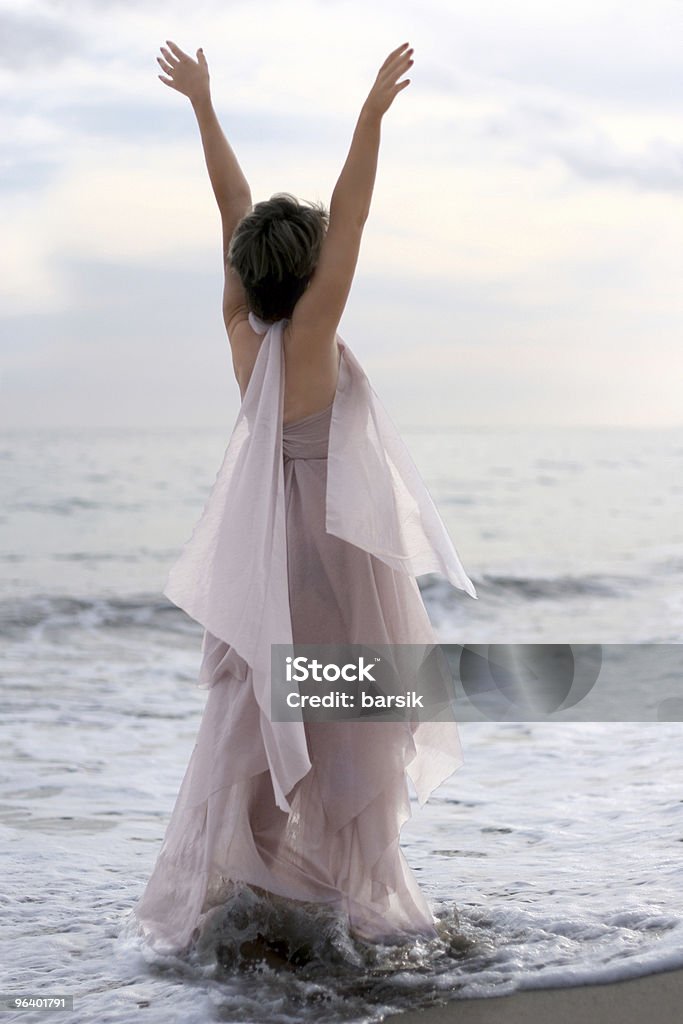 Mujer en vestido rosa en la playa - Foto de stock de Actividades recreativas libre de derechos