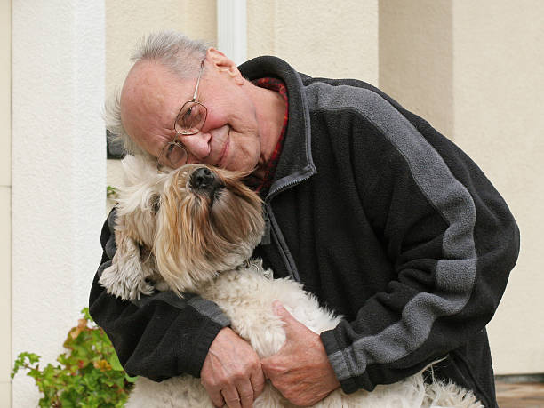 istock Senior man smiling and hugging his dog 96402117